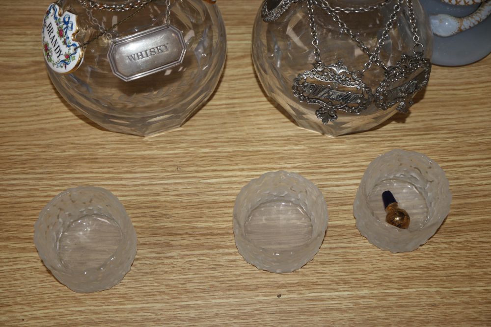 A pair of cut glass decanters, three other decanters, a claret jug and other glassware together with various labels, one silver whisky